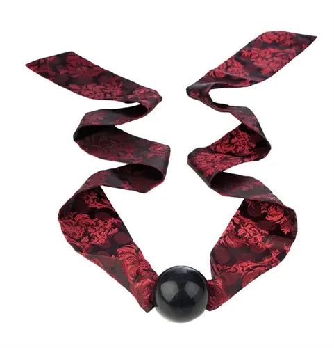 Ball gag with red-and-black patterned fabric straps and a black ball.